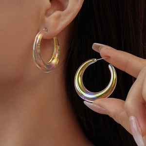 Detail of chunky iridescent acrylic hoop earrings showing aurora glow on model ear