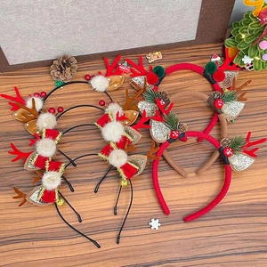 Variety of festive Christmas reindeer antler headbands with plush balls on a wooden surface