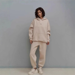 Detail of beige drawstring hoodie with kangaroo pocket and high waist joggers set