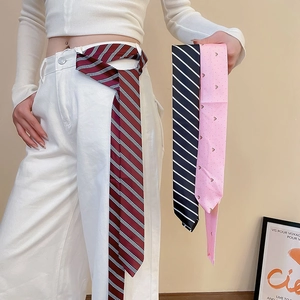 Detail showing a striped skinny scarf used as a stylish belt accessory on white trousers