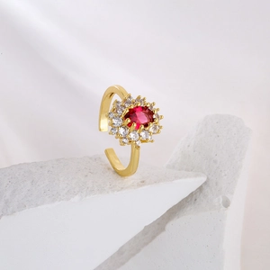 Macro detail of adjustable gold plated ring with red ruby and zircon flower design