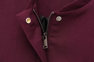 Détail de la veste bomber bordeaux avec fermeture éclair métallique et bouton-pression