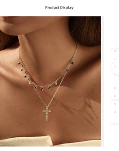 Detail of double-layer gold necklace with colorful drop charms and a diamond cross pendant