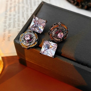 Close-up of vintage flower earrings with square zircon and pink gemstone detail