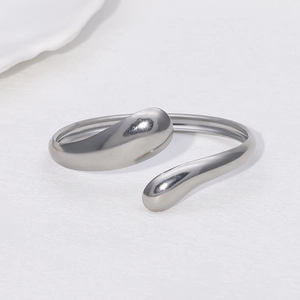 Macro shot of silver liquid-style open cuff bracelet with waterdrop design on white background