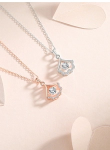 Close-up of fan-shaped silver and rose gold necklaces with dancing moissanite stones