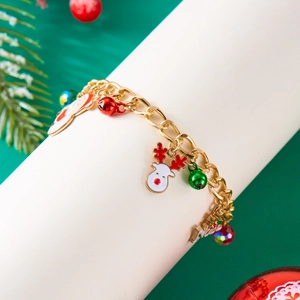 Close-up of golden Christmas bracelet with reindeer and bell enamel charms on a display