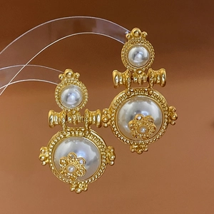 Detailed view of vintage gold drop earrings with pearls and small flower ornaments