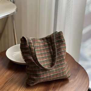 Detail of vintage striped tweed handbag with woven texture and a simple wish brand label