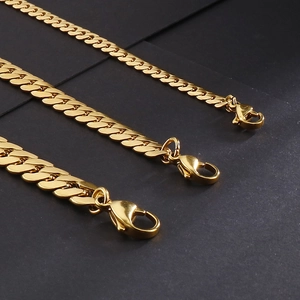 Three gold Cuban link chains in various thicknesses with lobster clasps on black background