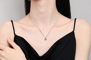 Detail of s925 silver moissanite necklace with six-prong setting on a female model