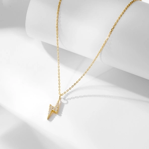 Macro detail of gold S925 sterling silver lightning bolt pendant with sparkling zircons