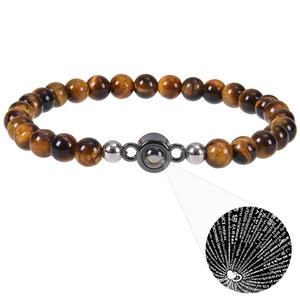 Macro detail of Tiger Eye beaded bracelet with 100 languages projection stone