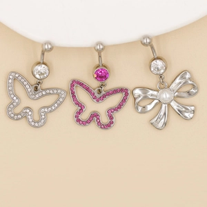 Close-up of stainless steel belly rings with butterfly and bow sparkling rhinestone charms