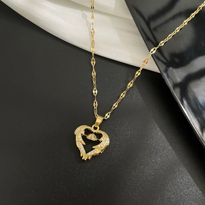 Elegant gold titanium heart necklace with winged pendant and sparkling cubic zirconia
