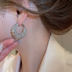 Close-up of elegant sparkling silver hoop earrings with pave diamonds on model