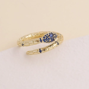 Detailed close-up of golden snake ring with scales and sparkling blue zircon inlay
