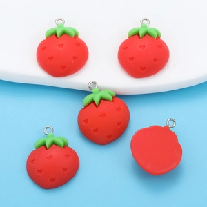 Detailed macro view of DIY strawberry resin pendants with heart textures and metal rings