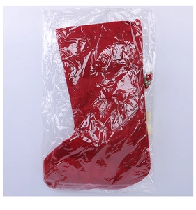 Detail of red Christmas stocking in clear packaging showing plush trim and felt texture