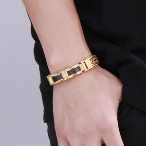 Detail of men's gold bracelet featuring black carbon fiber inserts and a central diamond