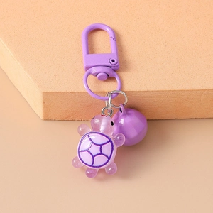 Detailed shot of purple resin turtle keychain with metal bell and spring clasp