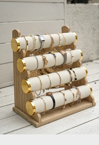 Detail of four-tier bamboo jewelry display stand with white velvet and gold metal edges