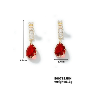 Detailed view of red pear-cut zircon earrings with gold setting, size 4.8cm by 1.4cm