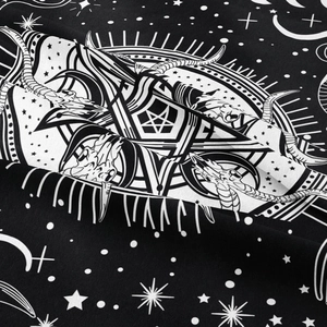 Macro detail of gothic pentagram and ram skull print on soft black and white tapestry