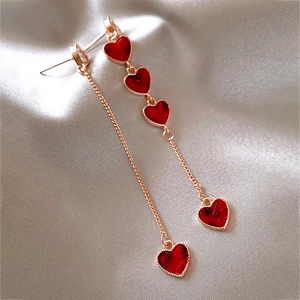 Asymmetric long tassel earrings featuring red heart pendants and golden metal chains