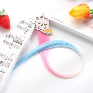 Detail of pink and blue gradient hair extensions with a glittery cat unicorn clip