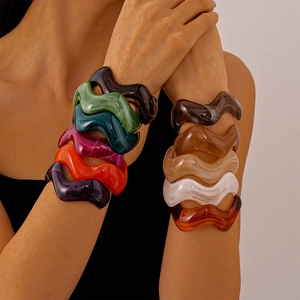 Irregular acrylic resin bangle with marbled pattern and wavy design on female wrist