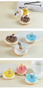 Detailansicht bunter künstlicher Donuts mit Zuckerstreuseln und Creme-Dekorationen