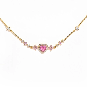 Macro detail of pink heart-shaped gemstone bracelet with gold plating and white diamonds
