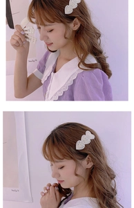Detailed view of pearl-studded heart and wave hair clips worn on a model's hair
