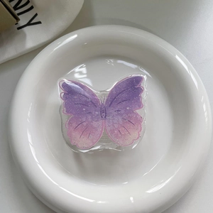 Macro shot of purple gradient butterfly phone grip with glitter finish on ceramic tray