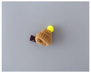 Detailed knit texture of mini wool beanie hair clip with yellow pompom and purple clasp