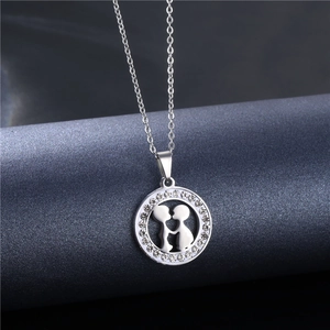 Elegant silver kissing couple necklace with sparkling crystal halo on a blue stand