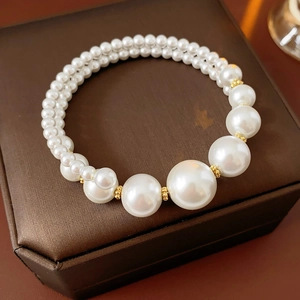 Gros plan d'un élégant bracelet en perles double couche sur un coffret cadeau brun