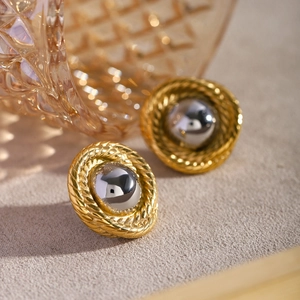 Close-up of 18k gold and silver two-tone twisted texture round stud earrings