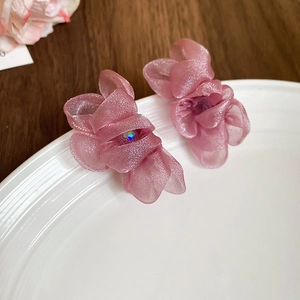 Detailed close-up of pink organza floral earrings with a central sparkling rhinestone