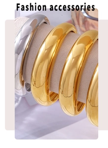 Close-up of sleek gold and silver C-shaped crescent bangles in polished titanium steel