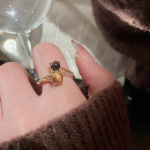 Detailed view of gold tiger eye ring with shimmering pavé cubic zirconia on hand
