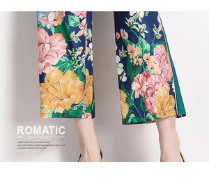Detailed view of the dark blue wide-leg pants featuring vibrant floral tropical prints