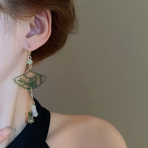 Detail of neo-Chinese fan earrings with green bamboo pattern and gold tassels on model