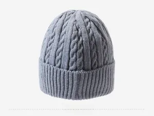 Macro detail of a gray cable-knit beanie featuring a thick ribbed cuff and soft texture