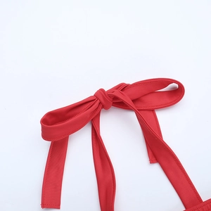 Détail de la robe rouge présentant un nœud papillon et les coutures du tissu extensible