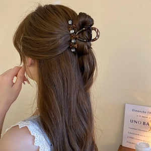 Close-up of tortoise shell hair claw clip with rhinestones in a half-up hairstyle