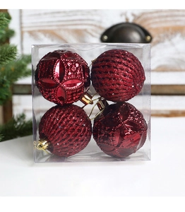 Macro view of four red Christmas ball ornaments with embossed textures in a clear gift box