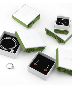 Detail view of the green ribbon bow on the white textured jewelry gift box