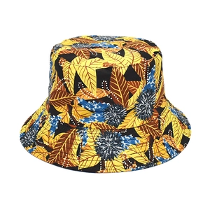 Détail des motifs tropicaux de feuilles jaunes et fleurs bleues sur ce chapeau bob